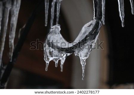 Hanging icicles on the roof of a house Royalty-Free Stock Photo #2402278177