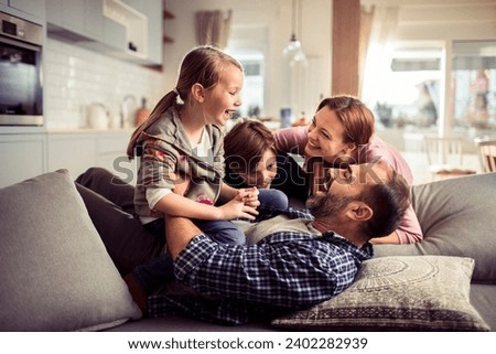 Happy family having fun on the couch at home Royalty-Free Stock Photo #2402282939