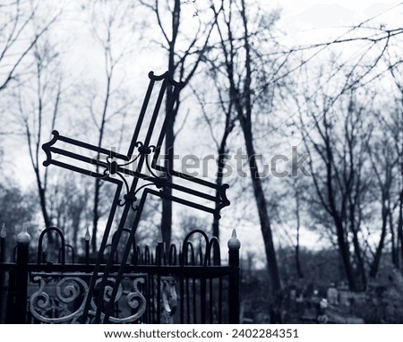 Metal cross at cemetery. Religious graveyard