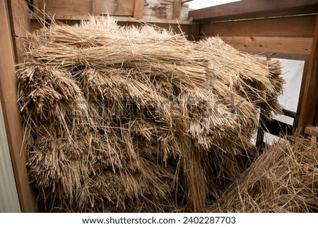 Straw piled up in a warehouse in a rural area of ​​Japan.