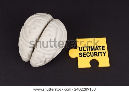 On a black surface lies a brain and a yellow puzzle with the inscription - Ultimate security. Business and technology concept.