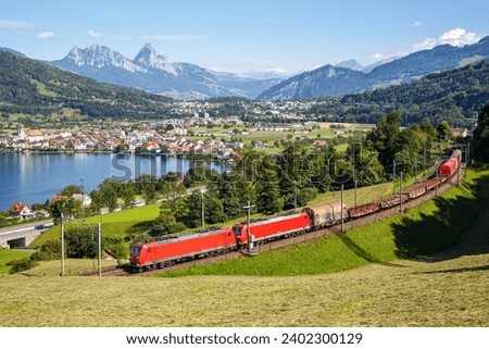 Freight goods train of DB Cargo at Grosser Mythen mountain at Lake Zug in the Swiss Alps in Arth, Switzerland Royalty-Free Stock Photo #2402300129