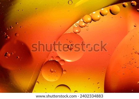 Orange drops of oil or serum texture background. Oil drops on the water's surface. Macro photography	 Royalty-Free Stock Photo #2402334883