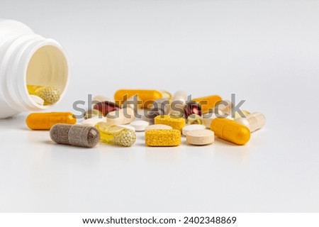 Pill bottle of vitamins and nutritional supplements isolated on white background. Wellness, health care and nutrition concept. Royalty-Free Stock Photo #2402348869