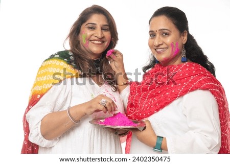 Indian happy women in Indian dress celebrating the Holi festival together with color powder.