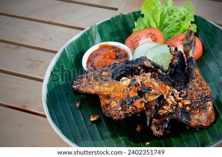 Grilled duck with vegetables placed in banana leaf