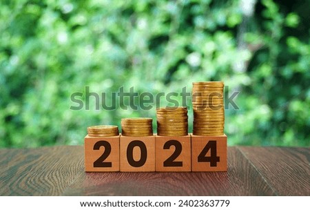 Stack coins on wooden block year 2024 using as business and financial concept. 2024 new year.