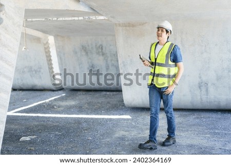 Professional senior Asian civil engineer working at the heavy infrastructure construction site, civil engineer - foreman inspecting the segmentation construction bridge.