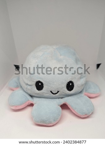 A blue octopus doll is smiling