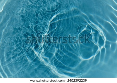 Defocus blurred transparent blue colored clear calm water surface texture with splashes and bubbles. Trendy abstract nature background. Water waves.