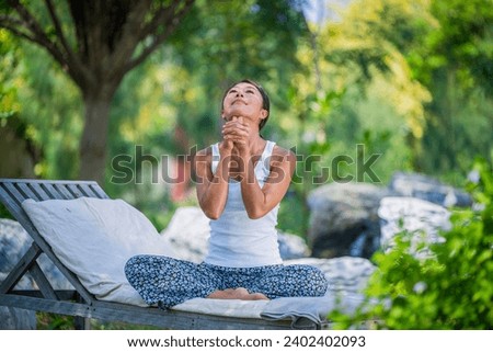 ํYoka young woman doing practice yoga in the garden for a workout lifestyle fitness and healthy. Yoga is meditation and healthy sport concept relaxing