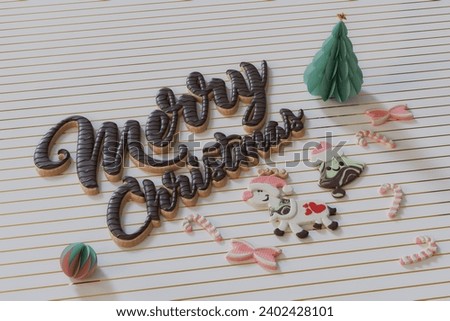 Image of sweet Christmas cookies and candy, chocolate merry Christmas text on a table top