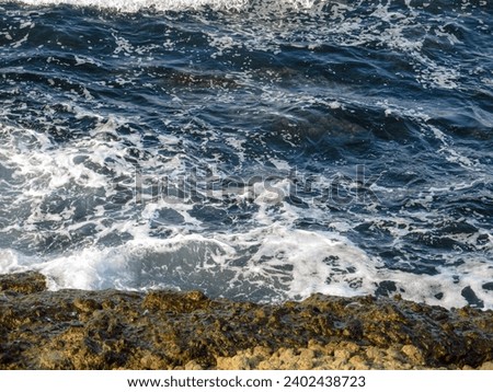 Sea with waves and rocks on the shore Royalty-Free Stock Photo #2402438723