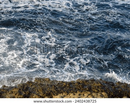 Sea with waves and rocks on the shore Royalty-Free Stock Photo #2402438725