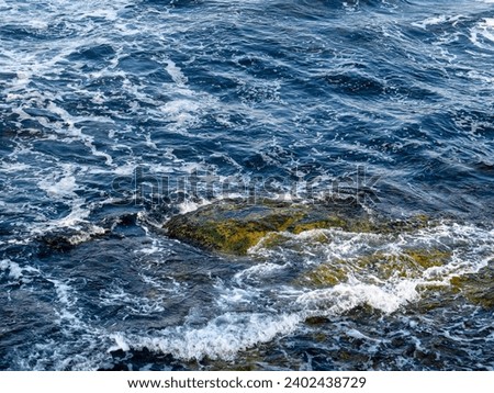 Sea with waves and rocks on the shore Royalty-Free Stock Photo #2402438729