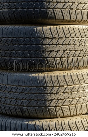 Stack of used car tires in natural light.