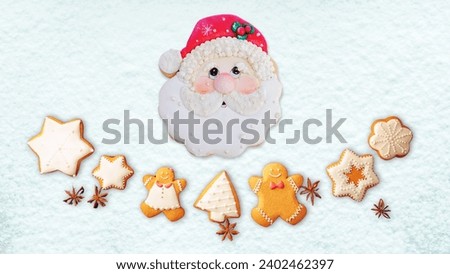 Christmas gingerbread cookies, with the shape of a santa, mr gingerbread, stars, Christmas tree, with snow decorations on top.