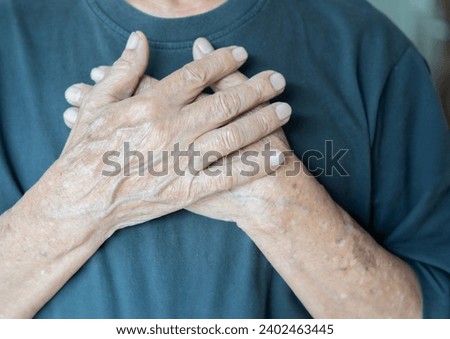 Crop close up of old man hold hands in prayer at heart chest feel religious superstitious. Adult male believer being grateful thankful pray to God. Faith, belief, religion concept.