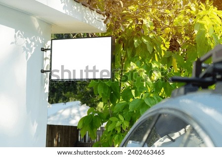 Blank sign mockup with white screen on car parking in resort at countryside. Copy space banner for advertisement background. Outdoor frame template poster media Ads display.