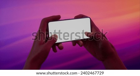 CU Caucasian male playing on his phone against purple vivid background. Blank phone screen game, rpg, racing, simulator application mockup