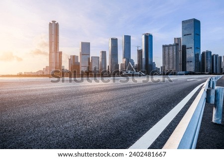 Asphalt highway road and modern city commercial buildings at sunset