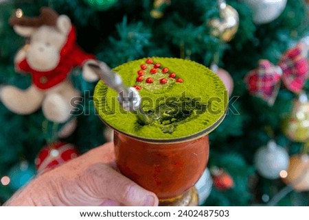 Traditional Brazilian chimarrão prepared with yerba mate (Ilex paraguariensis) decorated with a Christmas theme and with brazilwood seeds