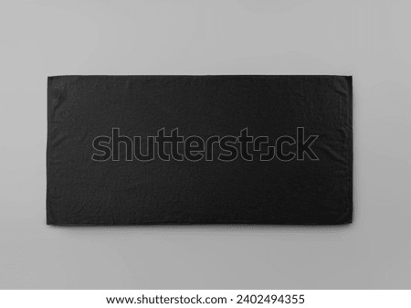 Template of trendy black towel with label isolated on background. Mockup of laid out terry towelling for wiping, for branding, design. Product photography, horizontal presentation
