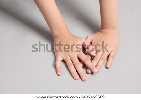 The Asian woman hand lying on the grey background.