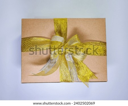 Handmade classic brown gift box with gold ribbon on white background, top view
