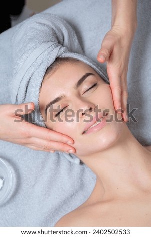 Young girl with perfect skin on a white background, towel on her head, beauty concept photo, skin care, spa concept, treatment, facial massage.
