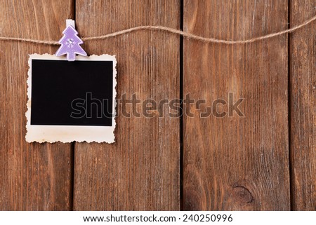 Blank photo frame and Christmas decor on rope on wooden background
