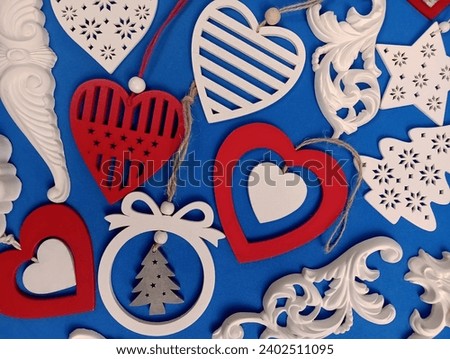White and red wooden New Year's toys on a blue background. Merry Christmas. St. Valentine's Day