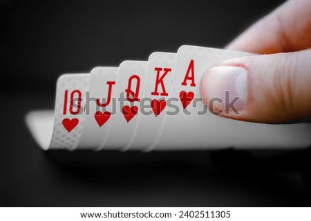 A person looking at a Royal flush An ace-high straight flush, the best possible hand in many variants of poker. Royalty-Free Stock Photo #2402511305