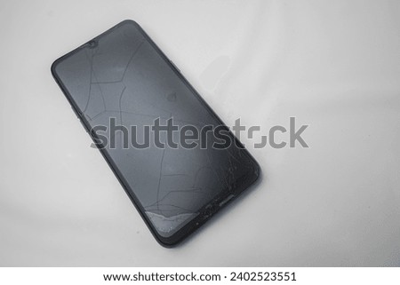 Cracked screen smartphone isolated on white background
