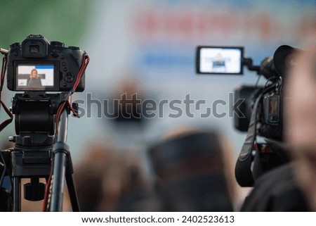 Media camera focuses on capturing the vibrant pulse of a buzzing media event Royalty-Free Stock Photo #2402523613