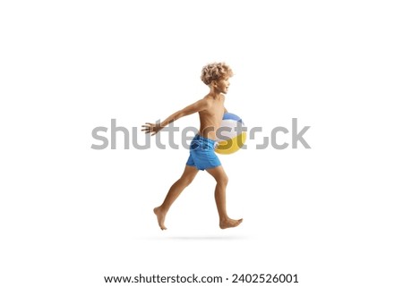Boy in swimming shorts running with a beach ball isolated on white background