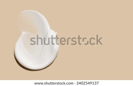 cosmetic smear of creamy texture on a beige background