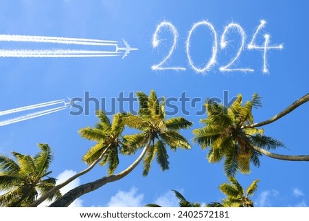 Happy New Year concept. Flying airplanes and 2024 writen with sparklers on blue sky.