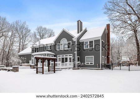 This snowy house with a large tree in the foreground is a striking image for a winter photo album