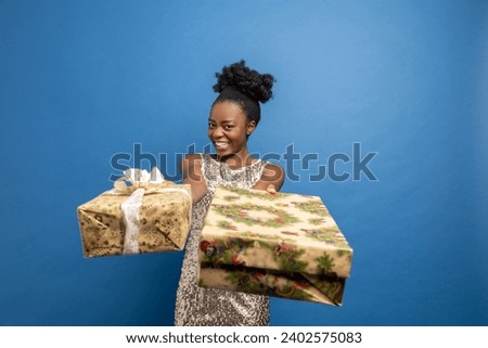 Pretty joyful young woman holding christmas gifts