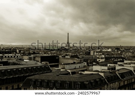 An aerial view of the cityscape of Paris in a rainy day with the Eifel tower in the background