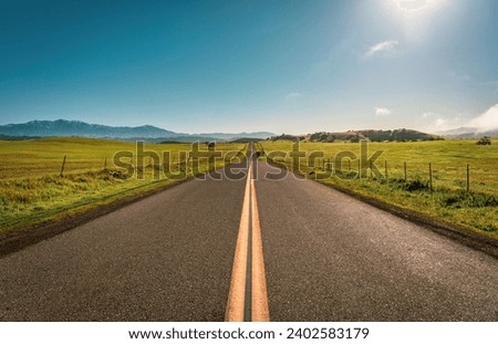 A spectacular view of a long road in Solvang, California, with the rolling hills in the background Royalty-Free Stock Photo #2402583179