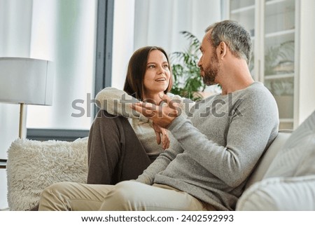 positive child-free couple talking on cozy couch in modern living room, quality time at home, banner Royalty-Free Stock Photo #2402592993