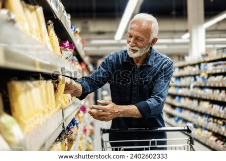 Retired man buying groceries. Mature Male Buyer Shopping Groceries in Supermarket.