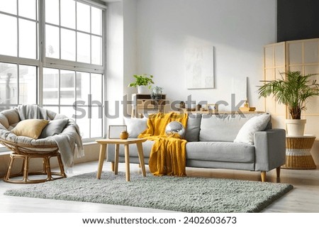 Interior of modern living room with disco ball on grey sofa, armchair and coffee table Royalty-Free Stock Photo #2402603673