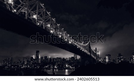 A low angle of the Manhattan bridge over the river with the background of the cityscape at night in New York City, USA