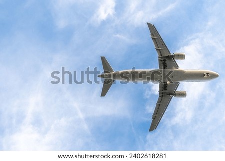 A picture of a large airplane soaring through the air on a cloudy day