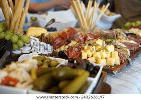 A delicious looking charcuterie board with a variety of gourmet cheeses, meats, and olives Royalty-Free Stock Photo #2402626197