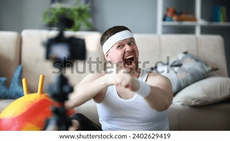 Screaming Vlogger Recording Boxing Video on Camera. Bearded Man Shooting Workout on Digital Camcorder for Fitness and Aerobic Vlog. Sportsman Doing Warmup Exercise for Hands Indoor Photography