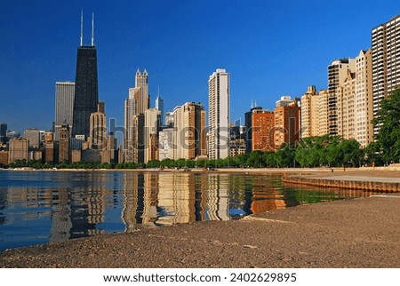The city skyline of Chicago is reflected in the still water of Lake Michigan Royalty-Free Stock Photo #2402629895